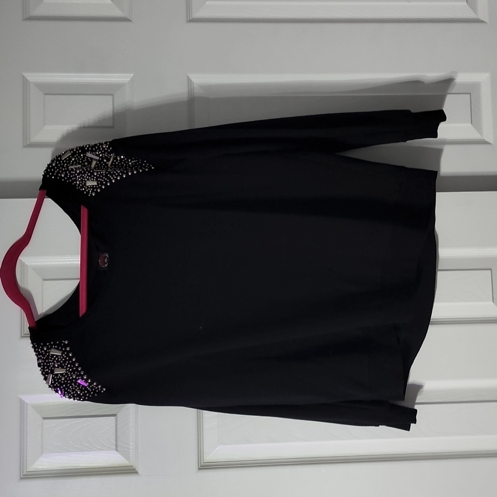 Rebel Wilson for torrid black sweater with beading on shoulder.